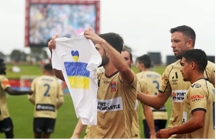 Footballer holding ukraine shirt